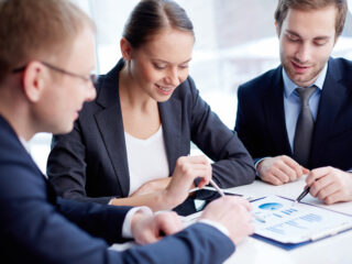 Confident business people discussing financial document at meeting