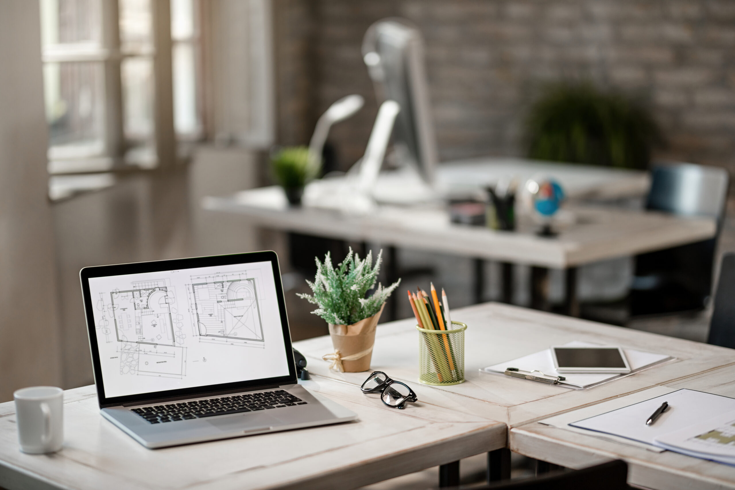 Architectural plans on screen of laptop in the office. Blueprints on computer monitor at the desk in real estate office.